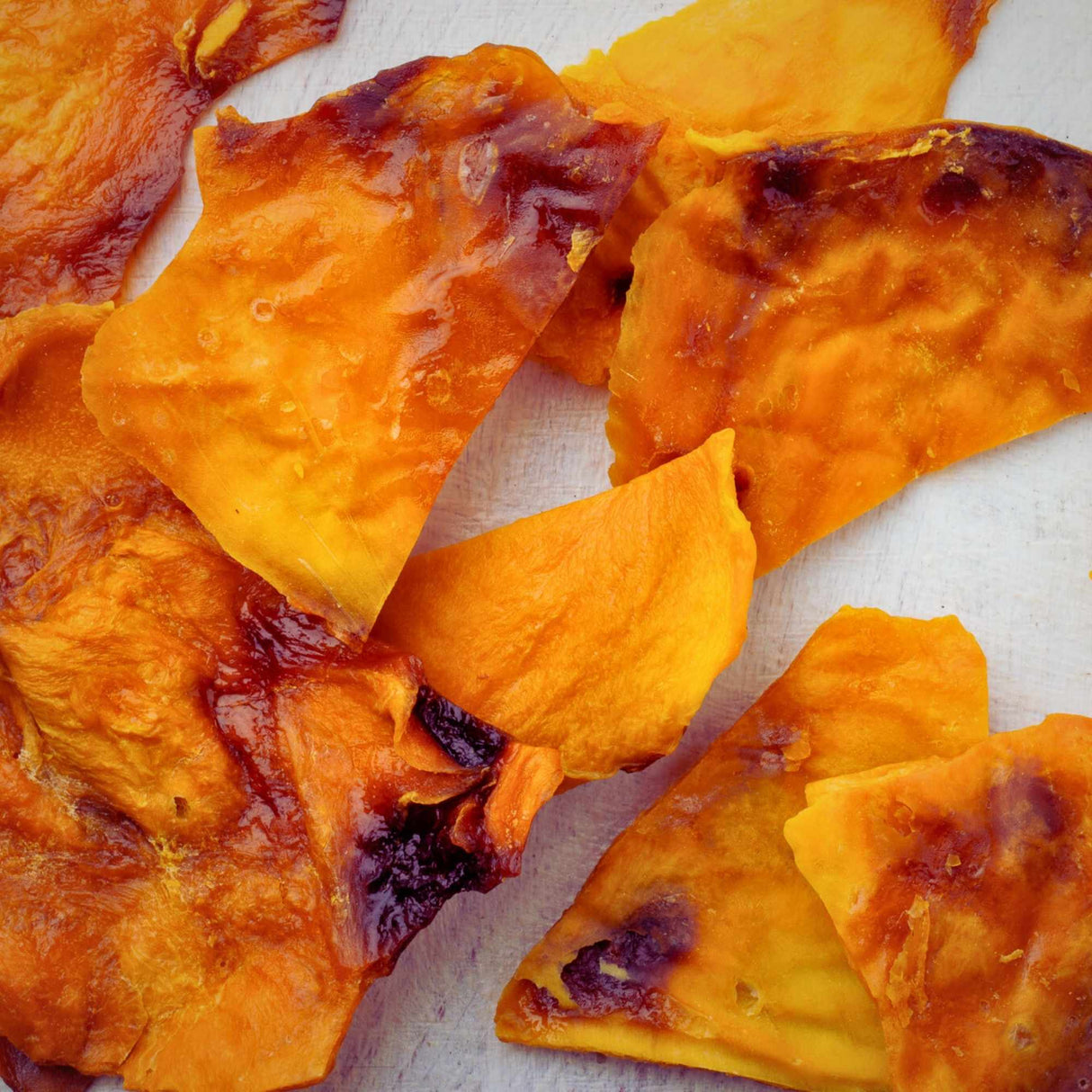 Close-up of glossy caramelised Australian dried mango slices showing natural sugar caramelisation.