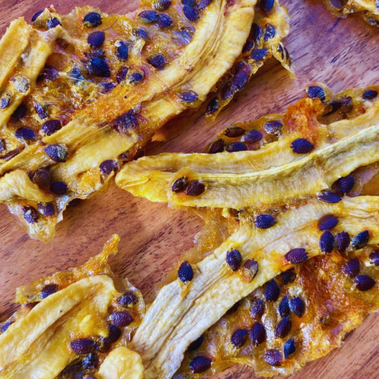 Dried banana infused with passionfruit showing vibrant seeds and rich chewy texture