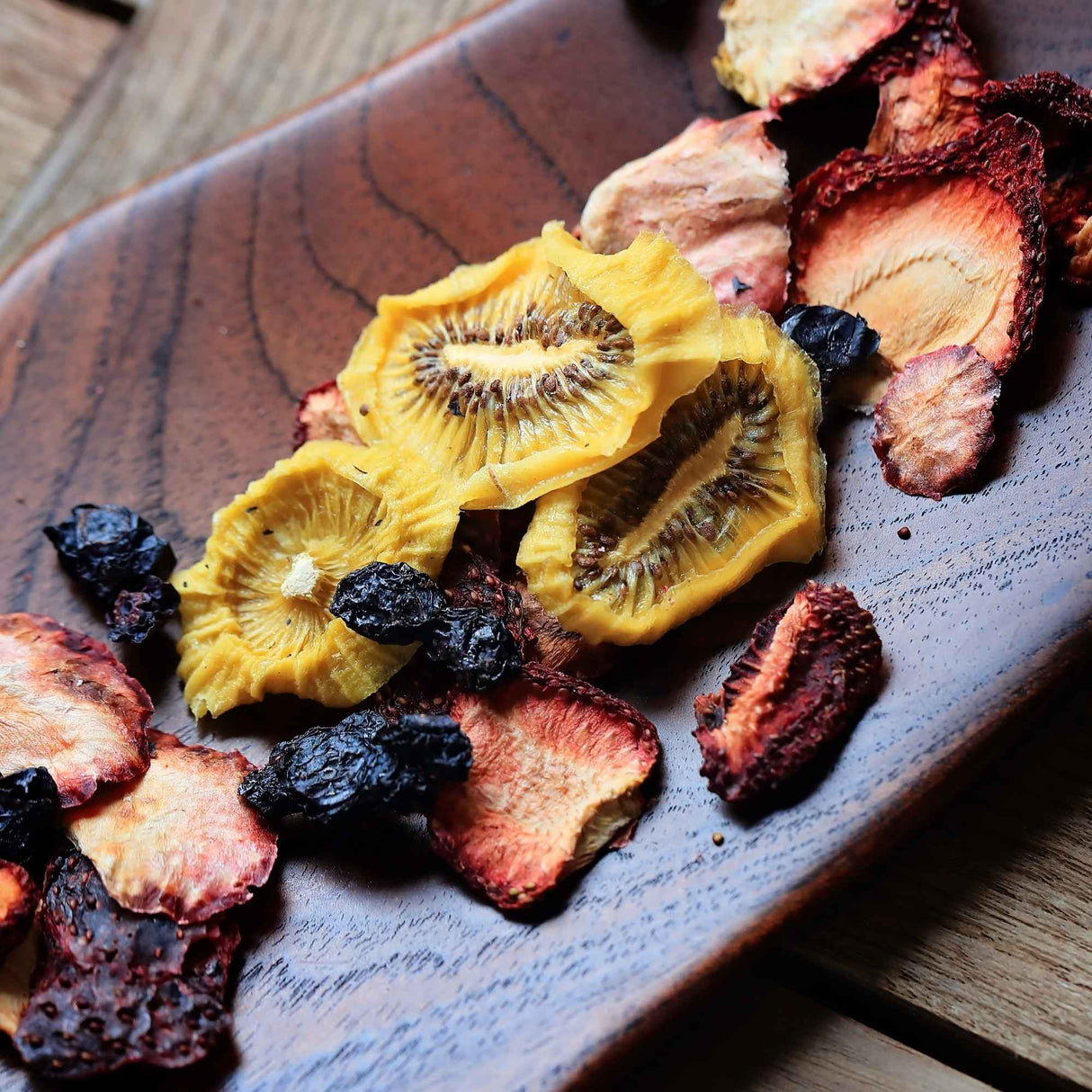 Dried fruit mix with kiwi strawberry and blueberry served on board for snacking and sharing