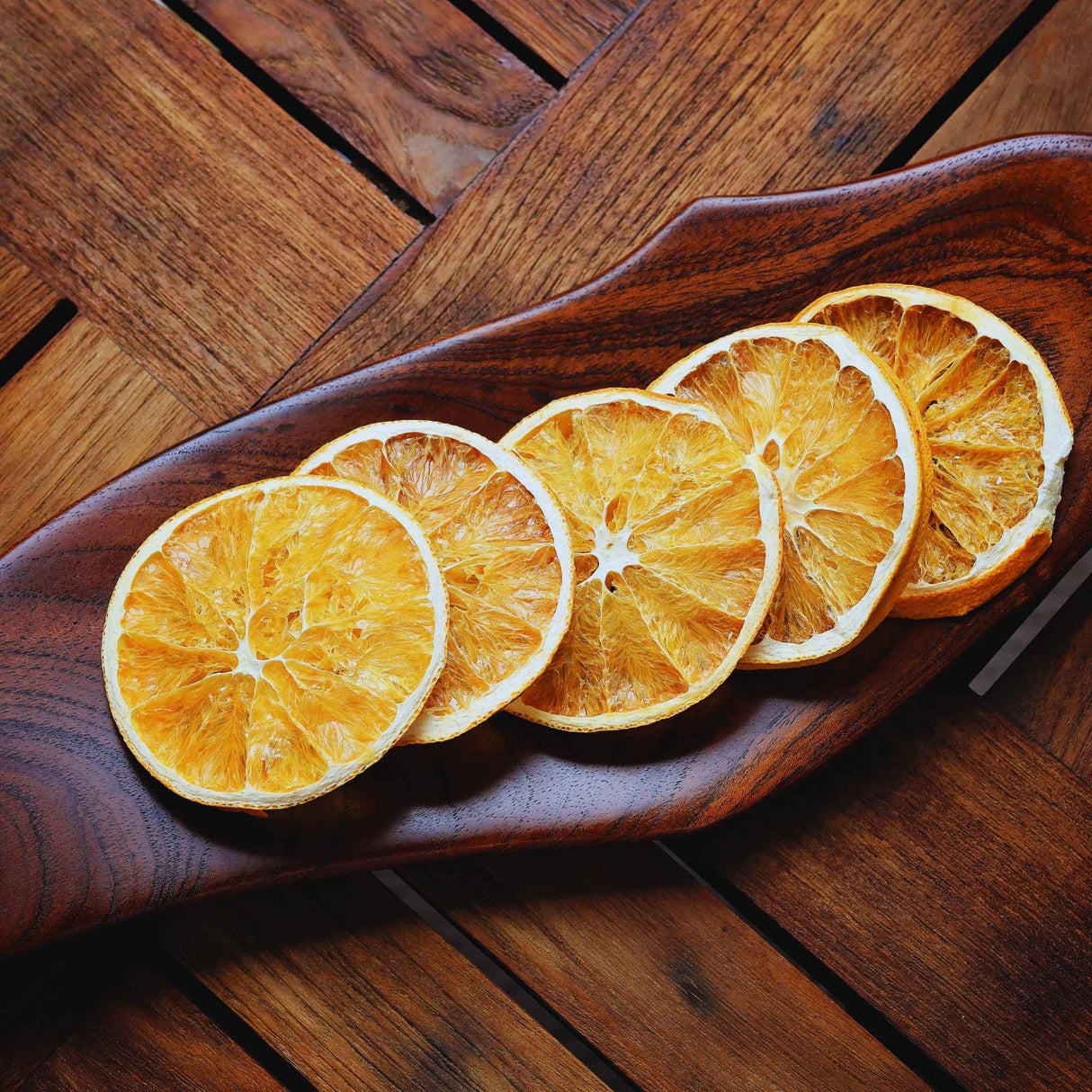 Dried orange slices arranged on wooden board for food styling and garnish use