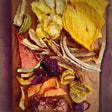 Close‑up of the Tropical Harvest dried fruit mix, showing vibrant colours and textures of multiple dried fruits (mango, banana, kiwi, dragon fruit, papaya, pineapple, apple, pear, strawberry and watermelon).