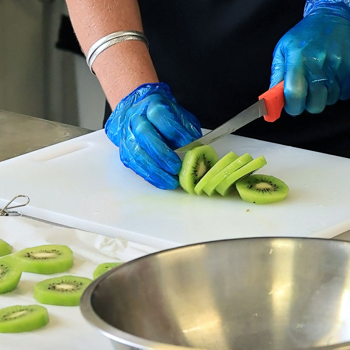 Fresh kiwi being sliced for drying showing preparation process