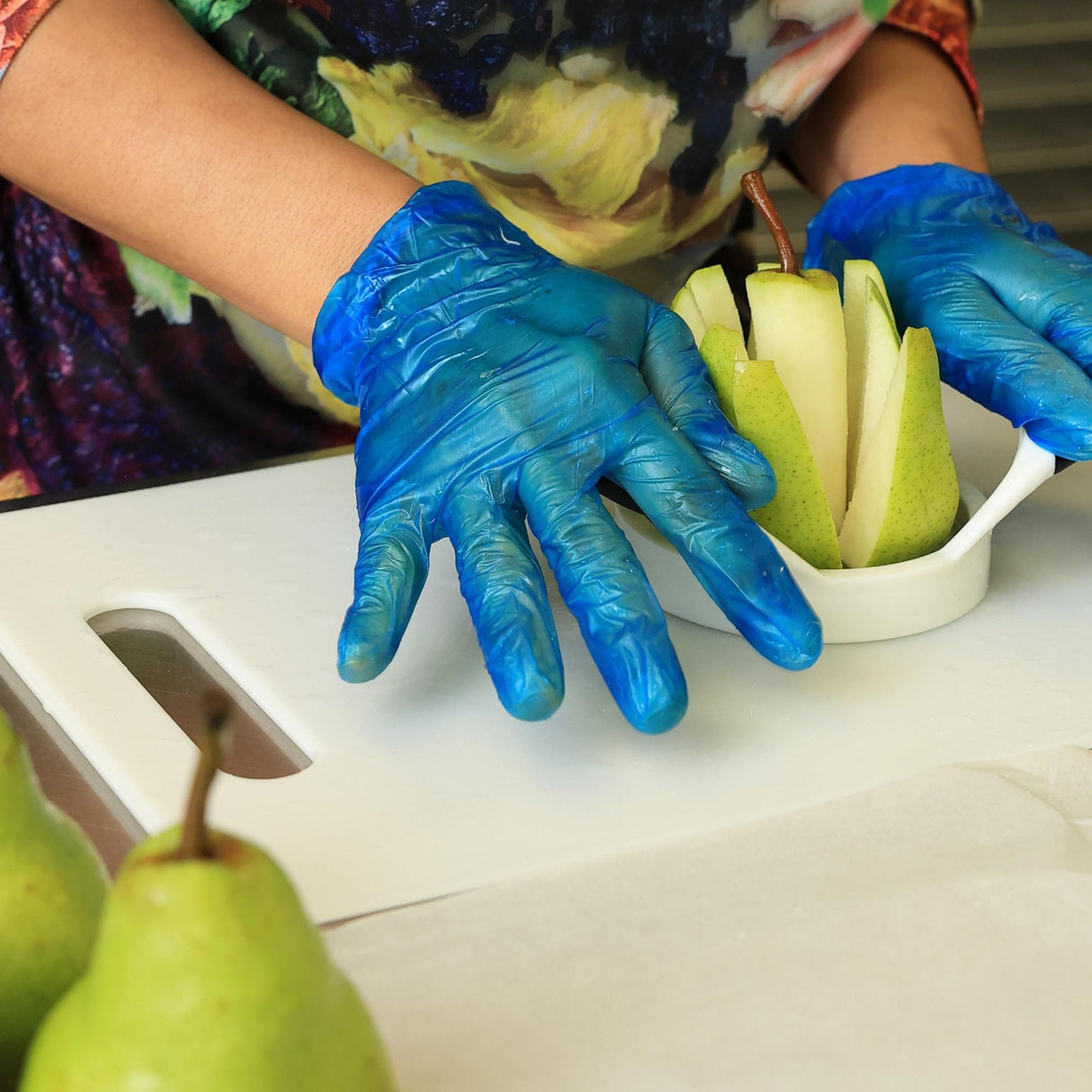 Fresh pears being sliced by hand showing preparation process for dried pears