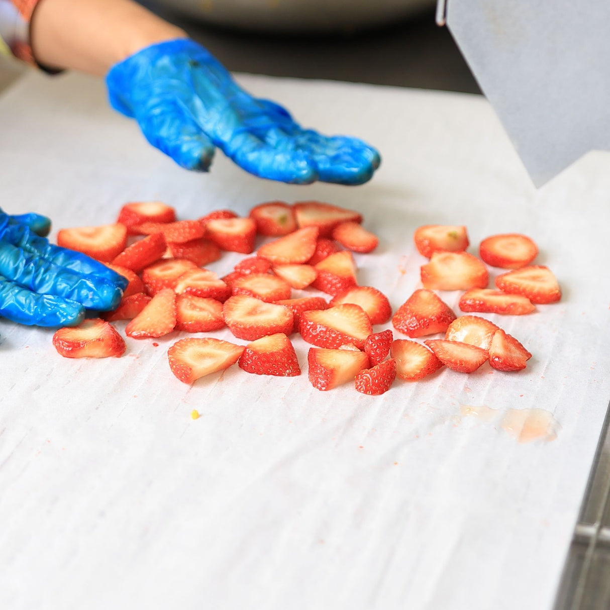 Fresh strawberries being sliced for drying showing preparation process