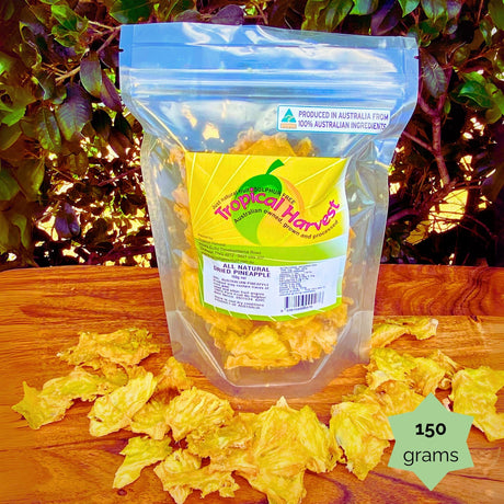 150g Tropical Harvest dried pineapple pack shown on wooden background. Ideal for snacking or gifting. No added sugar or preservatives.