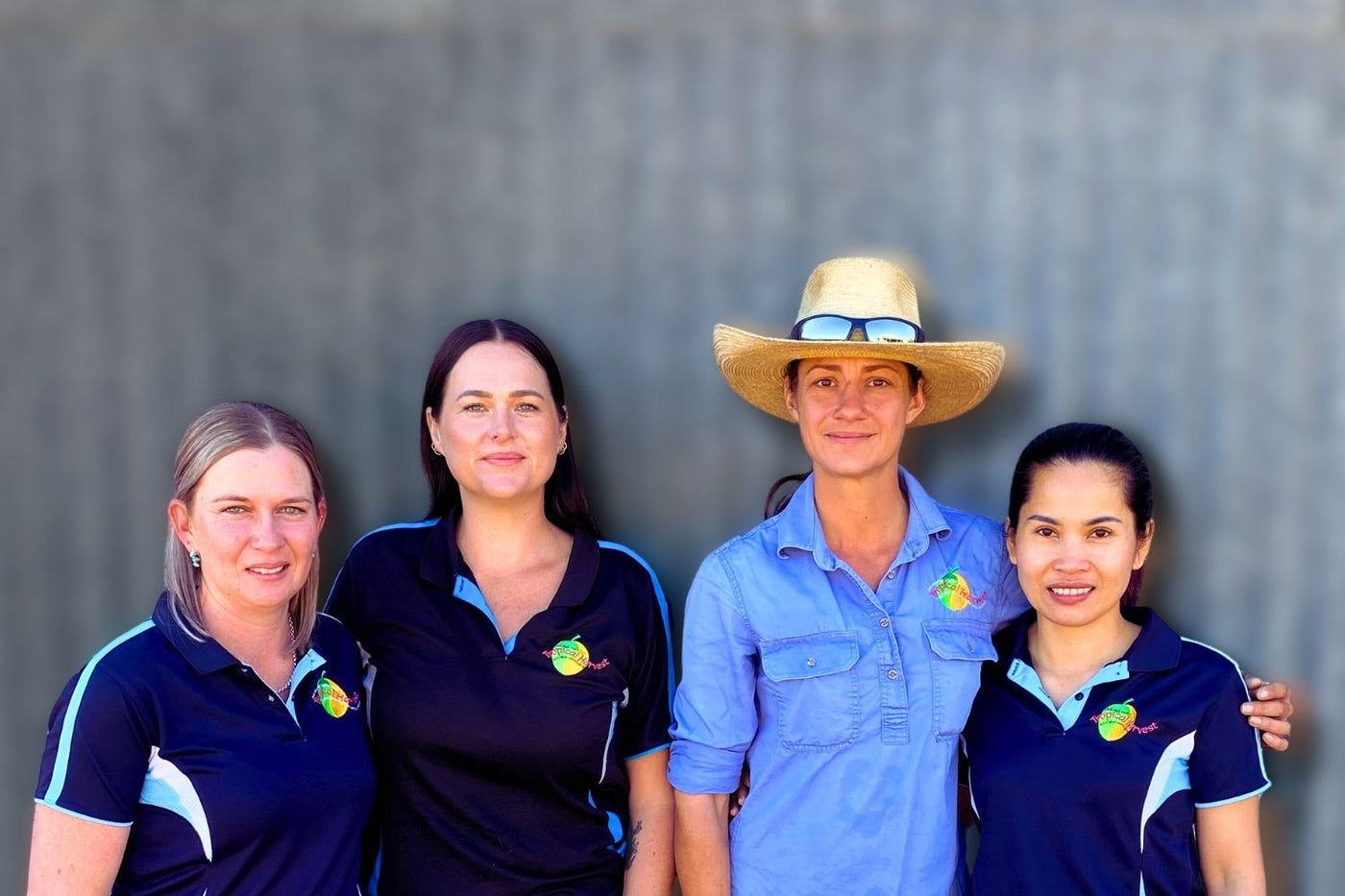 The Tropical Harvest team standing together at the orchard — the women who prepare, pack, and oversee every batch of dried fruit.
