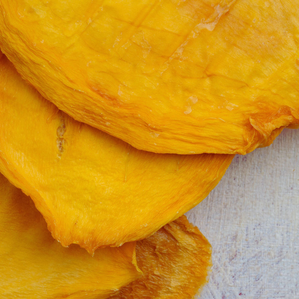 Close-up of dried Australian mango cheek slices showing thick, natural texture and vibrant orange-yellow colour