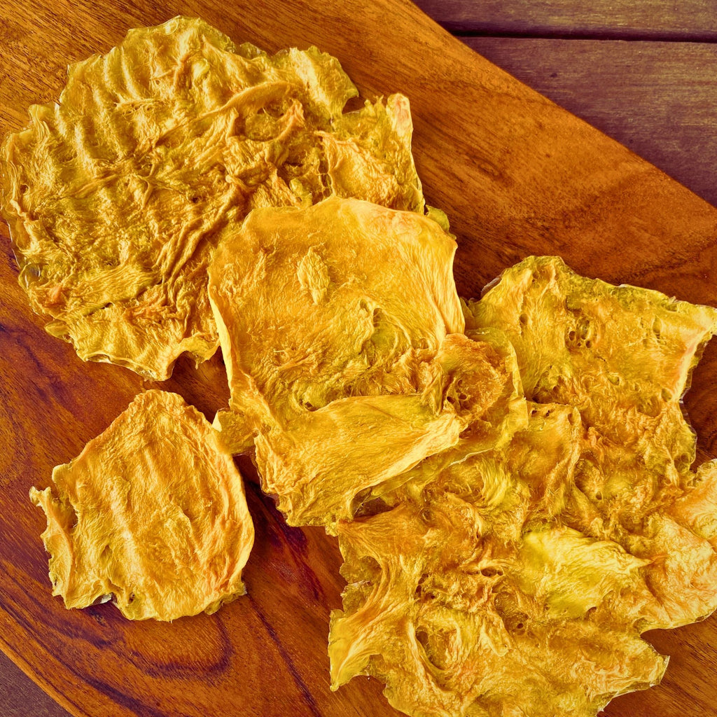 Close-up of natural Australian dried standard mango slices displayed on a wooden board – no sugar, no sulphur, no additives