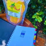 2026 planner and premium dried mango gift pack displayed outdoors with greenery backdrop