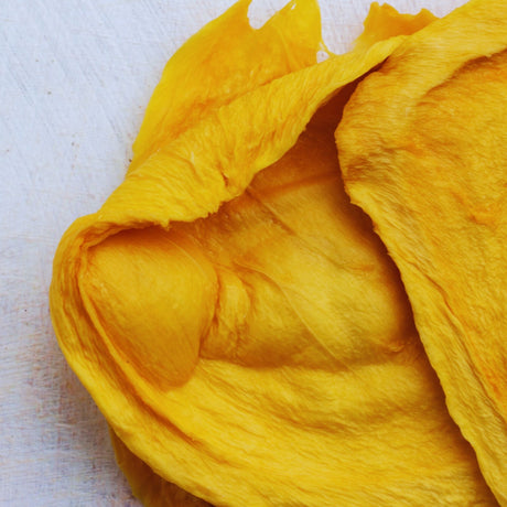 Close-up of Australian dried green mango cheek showing its natural pale colour and chewy texture.