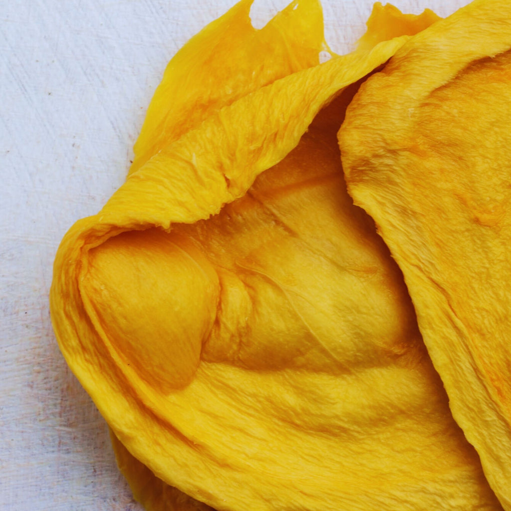 Close-up of Australian dried green mango cheek showing its natural pale colour and chewy texture.