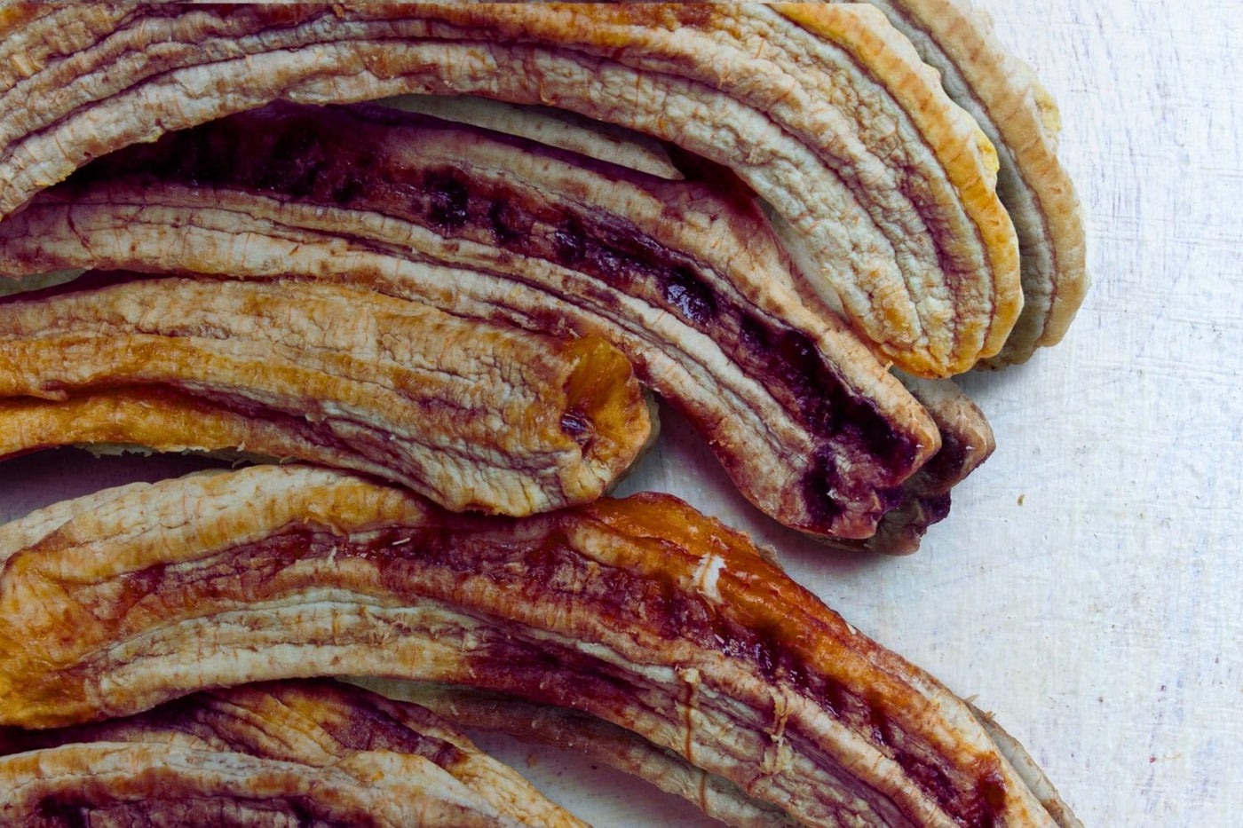 Close-up of dried Australian whole bananas – soft, chewy texture with golden tones and natural dark ripples. Part of the Tropical Harvest dried banana range.