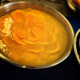 Australian dried mango slices dipped in fresh lime juice during mango lime preparation.