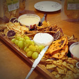 Australian dried mango with passionfruit pulp served on a grazing board with cheese and fruit.