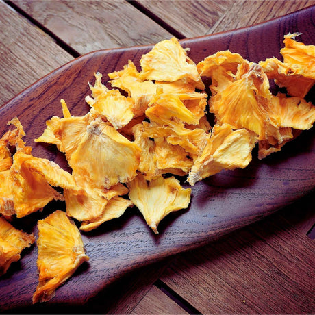 Tropical Harvest Australian dried pineapple pieces served on wooden board