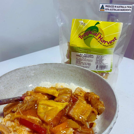 150g pack of Tropical Harvest Australian dried pineapple with dried pineapple pieces on plate