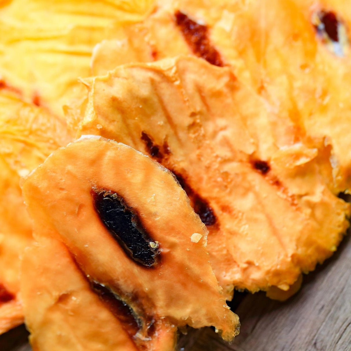 Close-up of caramelised Australian dried mango showing dark natural sugar caramelisation from slow drying.