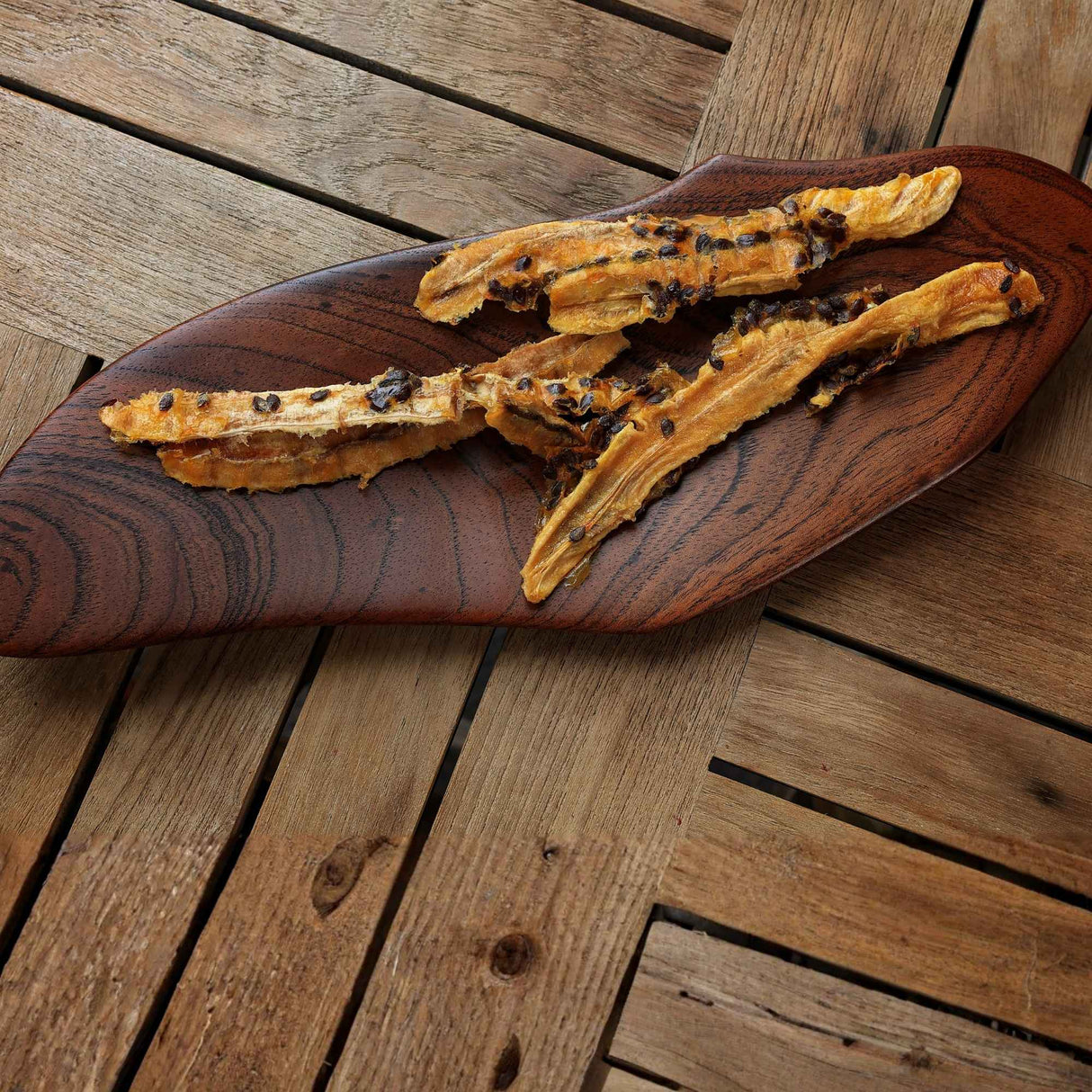 Dried banana passionfruit slices on wooden board showing natural tropical snack
