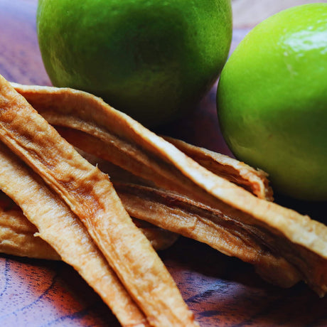 Australian dried banana with lime shown with fresh limes, highlighting the light citrus flavour and less sweet taste