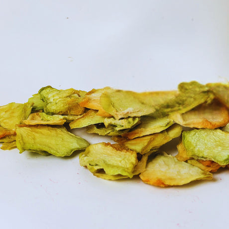 Dried honeydew melon slices on white background for healthy fruit snacking