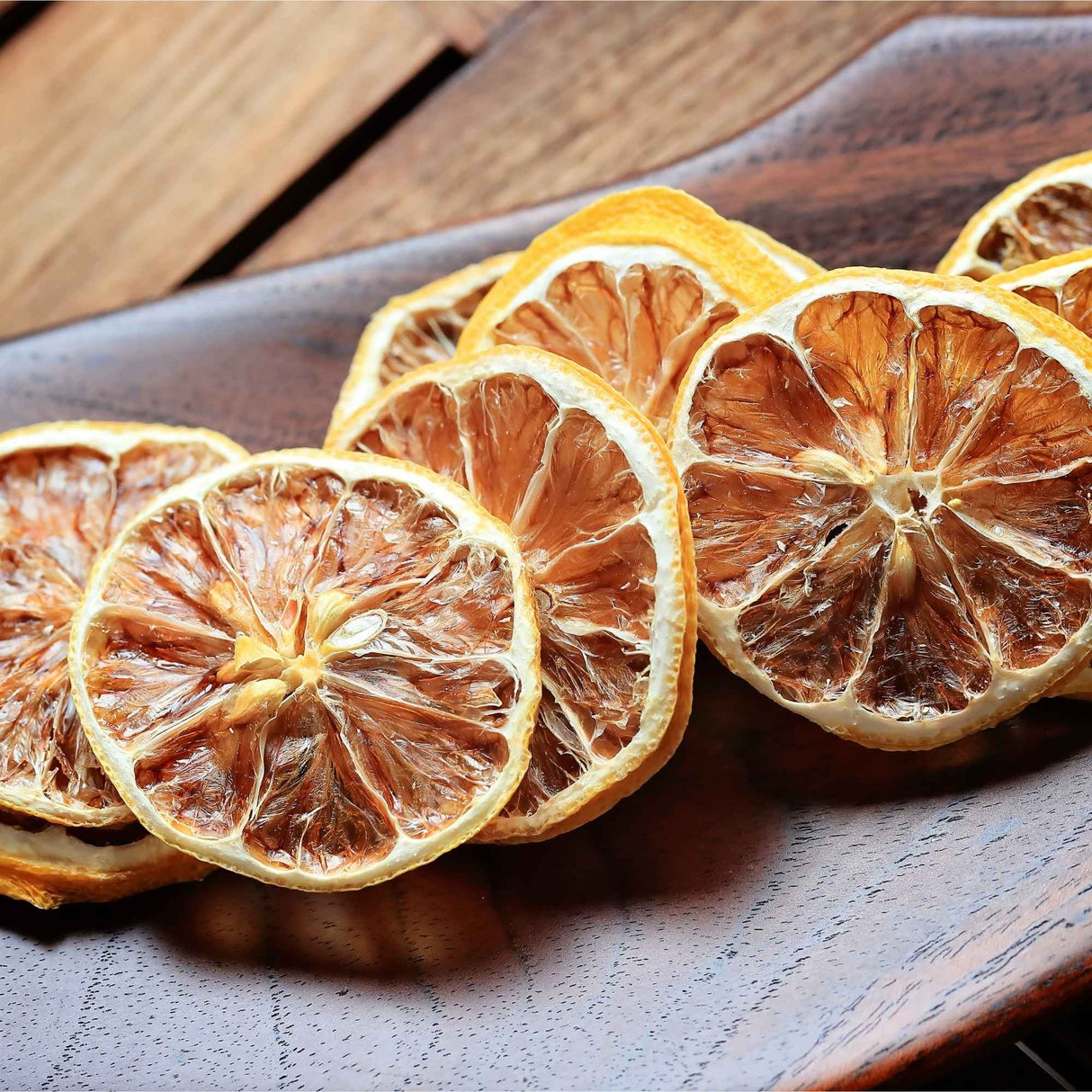 Dried lemon slices displayed on wooden surface for natural food styling and garnish use