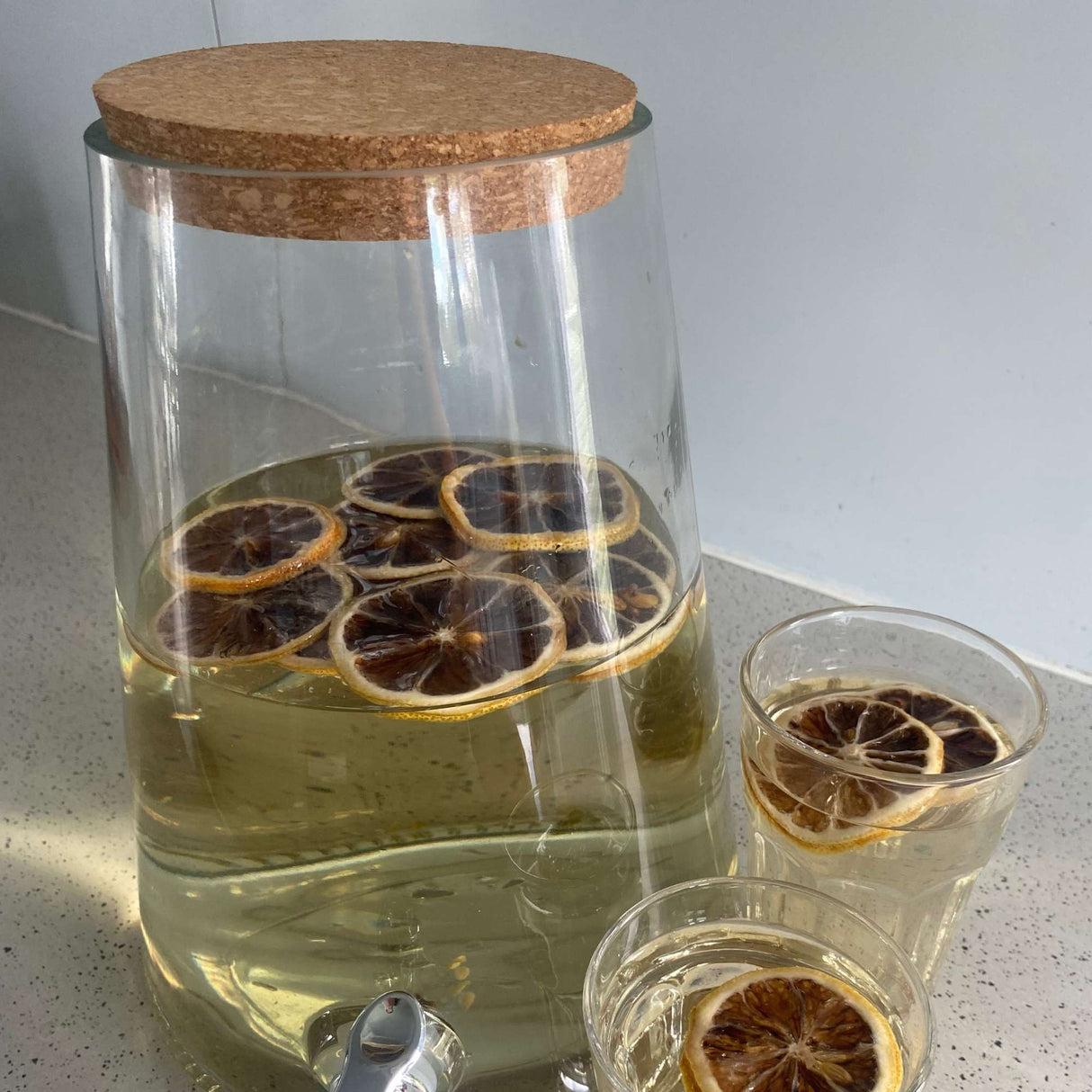 Dried lemon slices in water infusion jar creating refreshing lemon drink