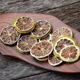 Dried lime slices arranged on wooden board for natural food styling and garnish use