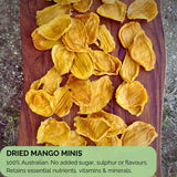 Flatlay of dried mango minis on a wooden board with text overlay highlighting 100% Australian-grown fruit, free from added sugar, sulphur, or flavours. Emphasises natural nutrient retention and clean ingredients.