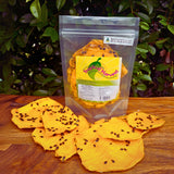 Dried passionfruit mango 150g pack with visible product label showing sulphur-free, Australian-grown ingredients and resealable packaging. Large upright bag of dried mango infused with real passionfruit, with seed-speckled slices displayed in front on a wooden surface.