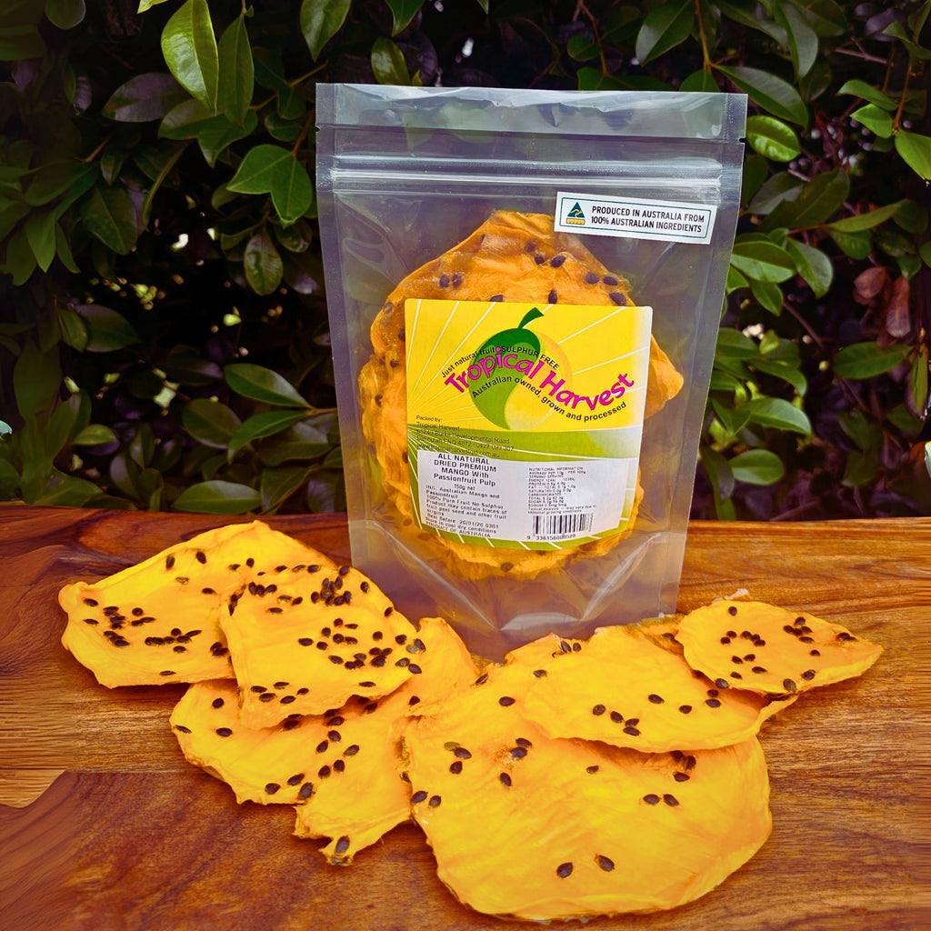 Dried passionfruit mango 150g pack with visible product label showing sulphur-free, Australian-grown ingredients and resealable packaging. Large upright bag of dried mango infused with real passionfruit, with seed-speckled slices displayed in front on a wooden surface.