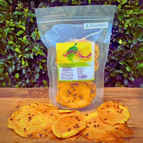 Dried passionfruit mango 350g pack with visible product label showing sulphur-free, Australian-grown ingredients and resealable packaging. Large upright bag of dried mango infused with real passionfruit, with seed-speckled slices displayed in front on a wooden surface.