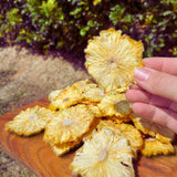 Dried pineapple flowers arranged on a wooden board showing natural tropical fruit slices