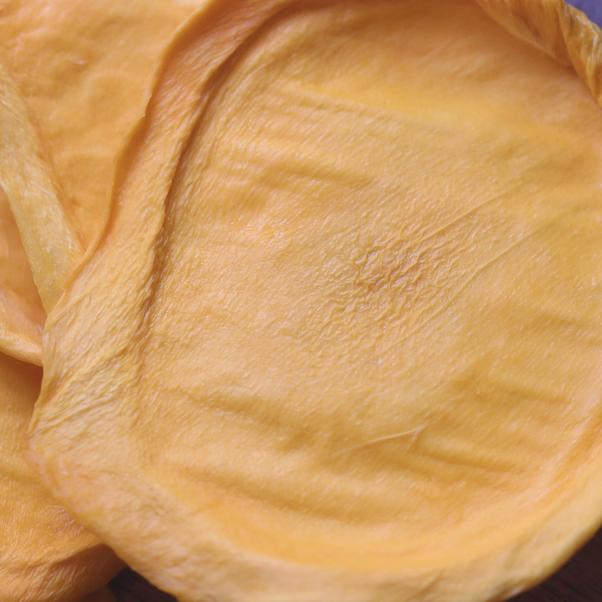 Close-up texture of Green Australian dried mango highlighting its smooth surface and firm structure.