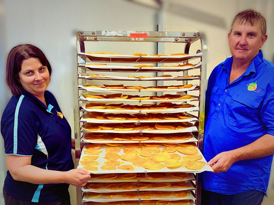 James and Janelle from Tropical Harvest showing trays of slow-dried Australian mango slices in their facility