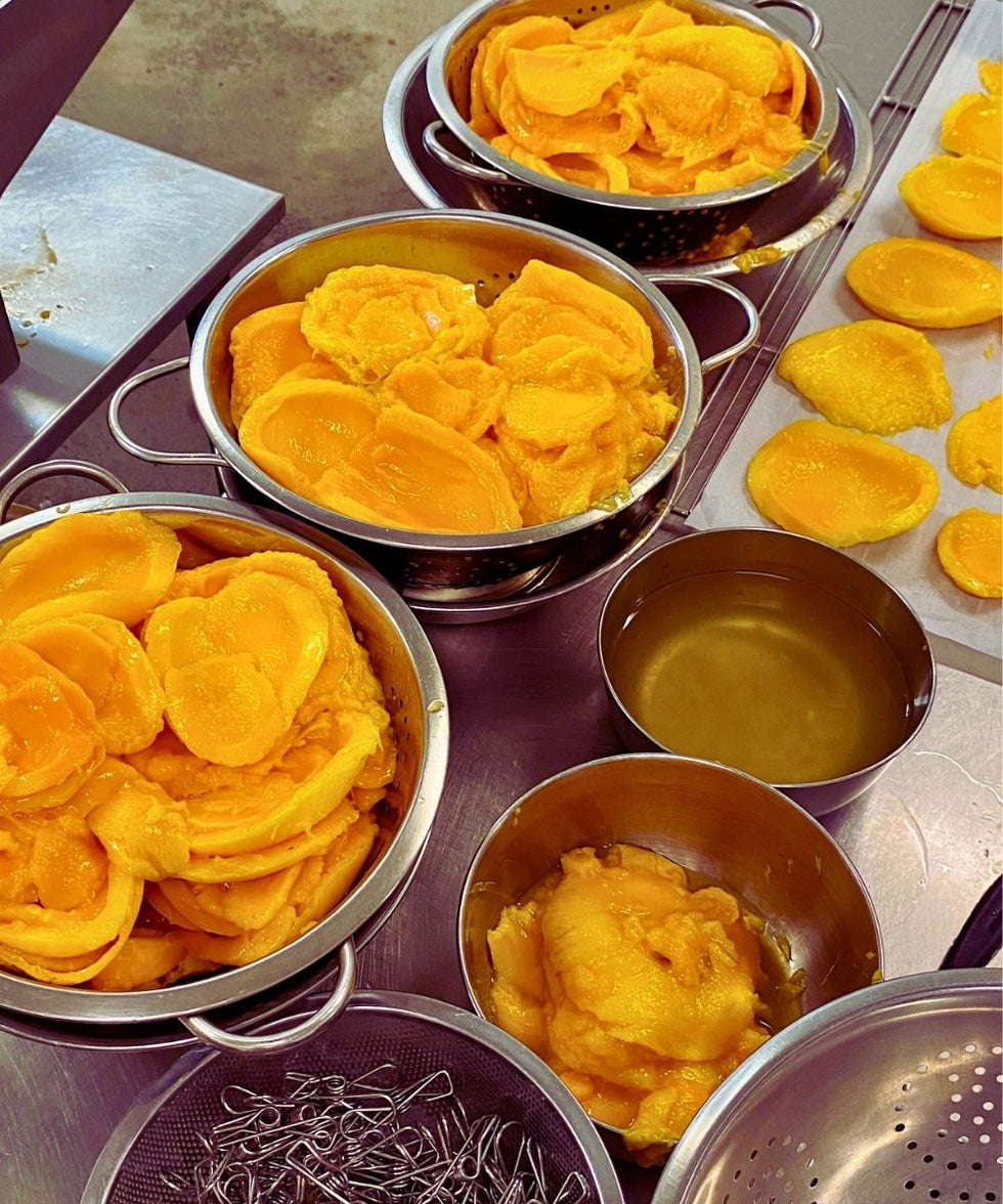 Close-up of ripe mango being prepared for drying in a commercial processing setup in Australia