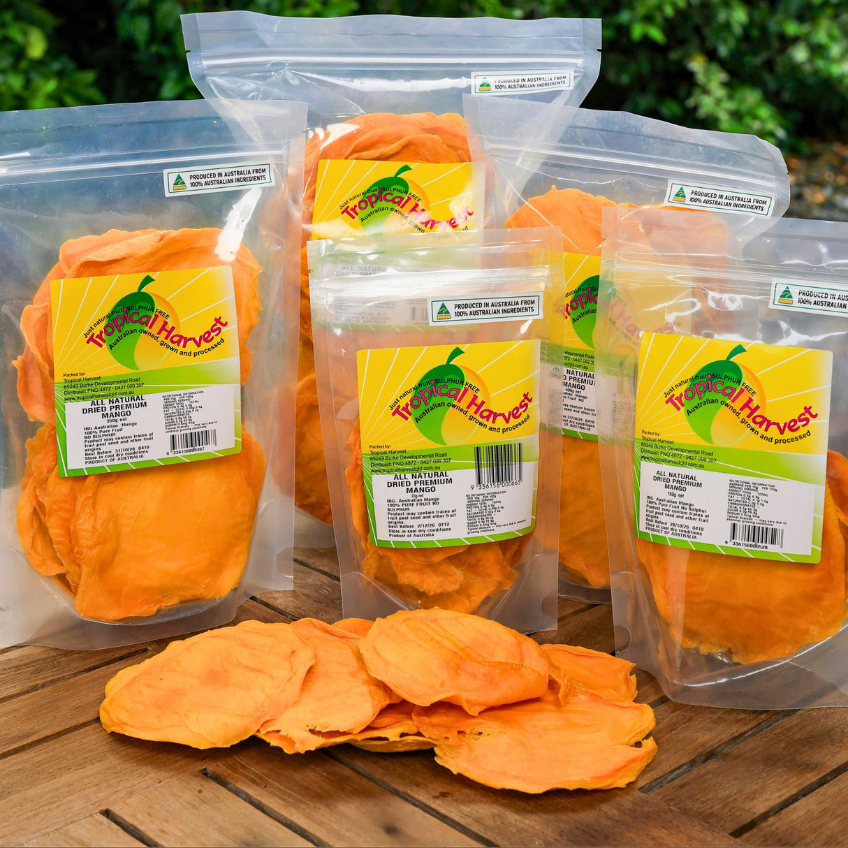 Premium Australian dried mango range displayed outdoors with multiple resealable bags and mango slices.