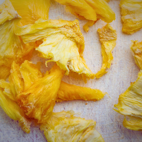 Close-up of Tropical Harvest dried pineapple showing vibrant yellow texture and natural fibres. 100% Australian fruit with no additives.