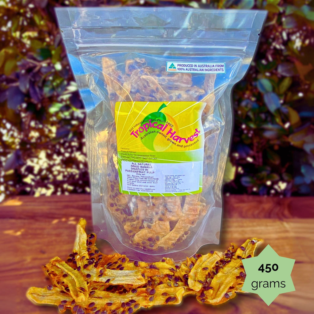 450g Tropical Harvest dried banana with passionfruit pulp resealable pack. Chewy banana strips with tangy passionfruit seeds are shown on a wooden background.