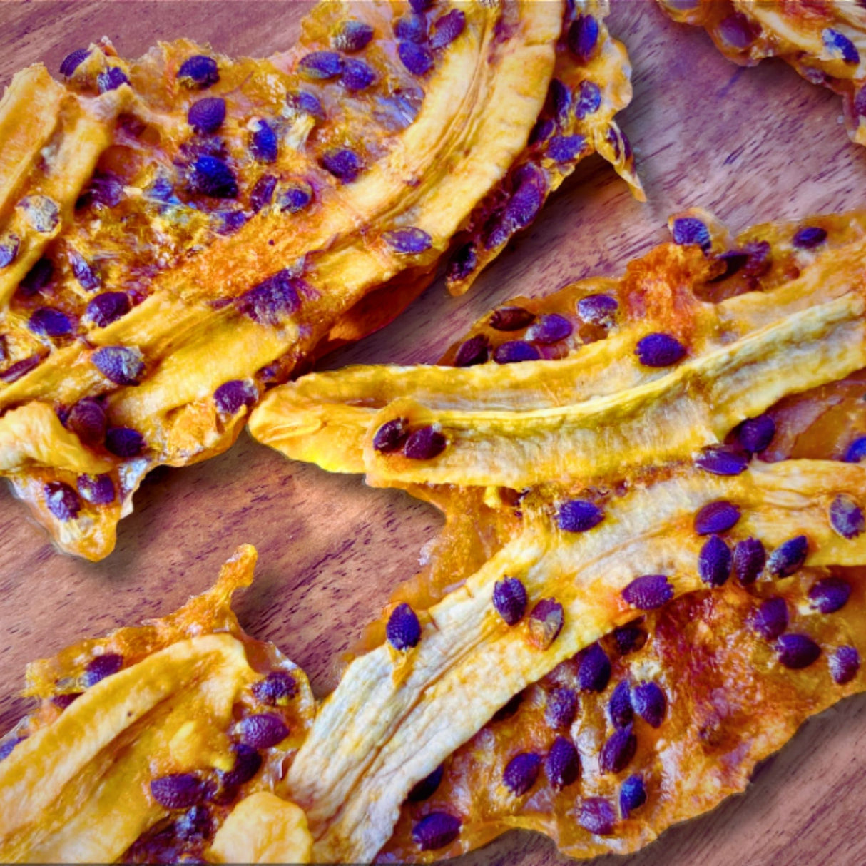 Close-up of Tropical Harvest dried banana strips drizzled with real passionfruit pulp and seeds. Naturally chewy, tangy, and 100% Australian fruit.